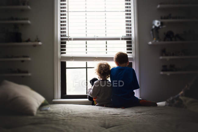 Irmãozinhos sentados na cama — Fotografia de Stock