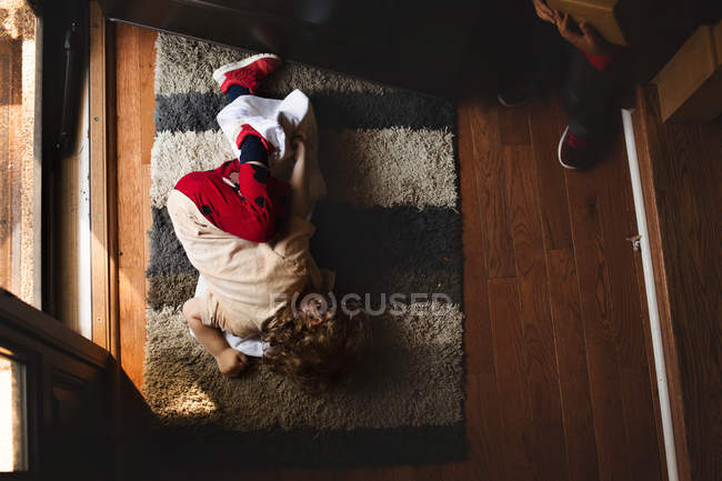 Мальчик лежит на ковре — стоковое фото