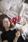 Jeune femme avec chien avec ballons rouges en forme de mot amour, foyer sélectif — Photo de stock