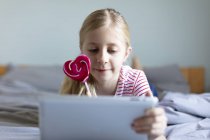 Beautiful girl using digital tablet at home, focus on foreground — Stock Photo