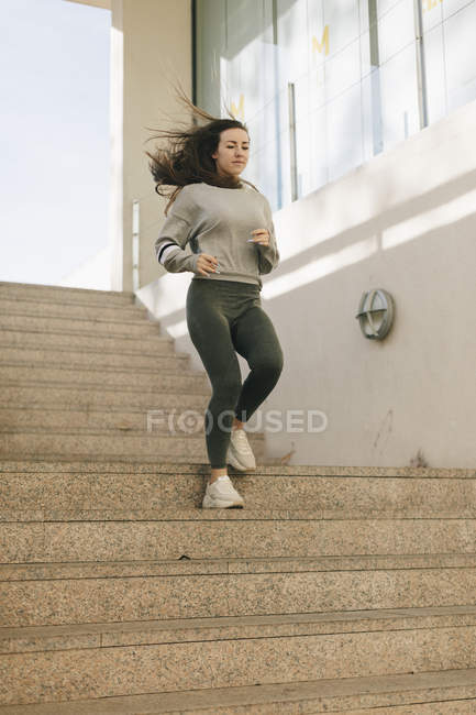 Девушка в спортивной одежде тренируется на улице — стоковое фото