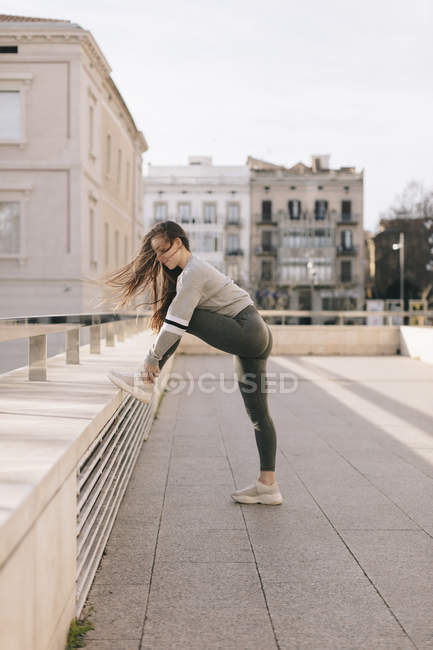 Молода жінка в спортивному одязі тренується на вулиці — стокове фото