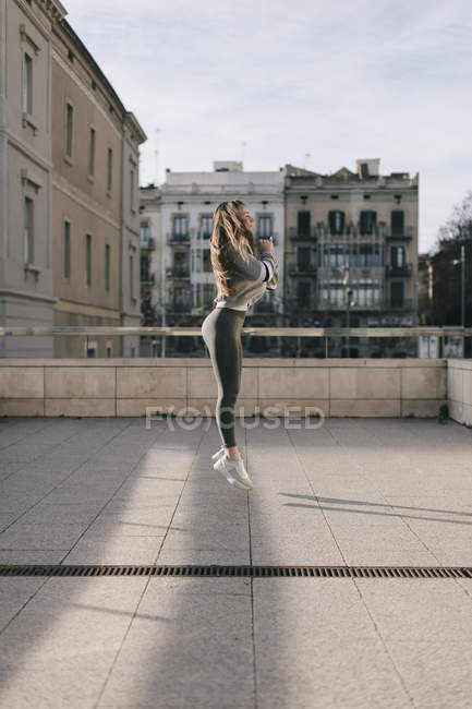 Jeune femme en sportswear formation à la rue — Photo de stock