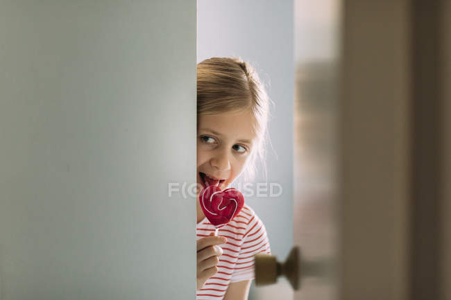 Mädchen isst Karamell-Lutscher zu Hause, selektiver Fokus — Stockfoto