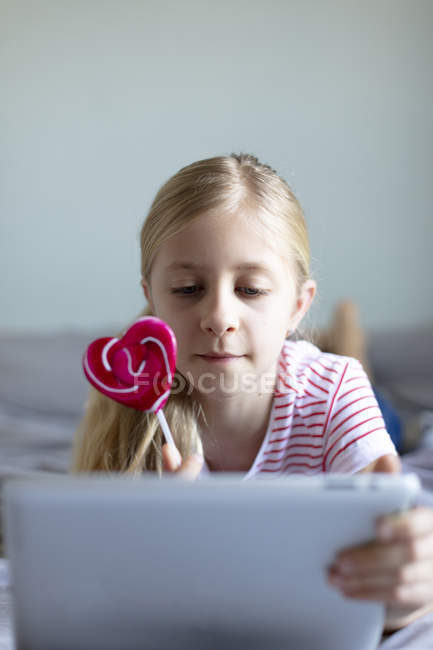 Красива дівчина в домашніх умовах, використовуючи цифровий планшетний зосередитися на передньому плані — стокове фото