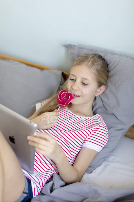 Beautiful girl using digital tablet at home, focus on foreground — Stock Photo