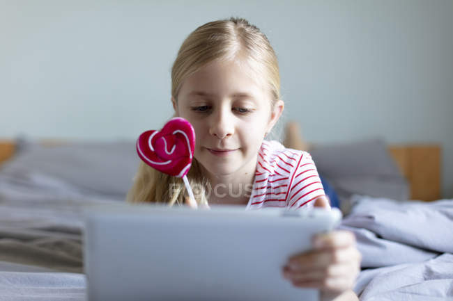 Красива дівчина використовує цифровий планшет вдома, фокус на передньому плані — стокове фото