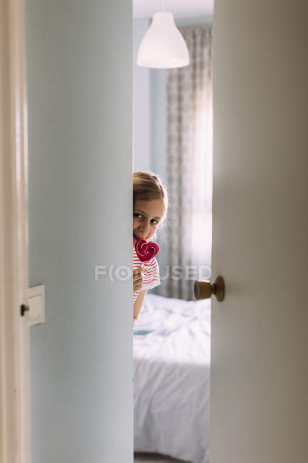 Girl eating pink lollipop at home, selective focus — Stock Photo