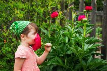 Mädchen riecht Pfingstrose Blume — Stockfoto