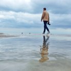 Чоловік самотньо гуляє на пляжі — стокове фото