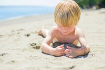 Мальчик играет в песок — стоковое фото