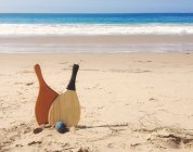 Beach paddle and ball in sand — Stock Photo
