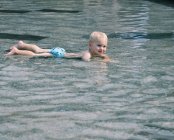 Junge liegt im Wasser — Stockfoto