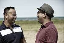 Due uomini sorridenti sulla spiaggia — Foto stock