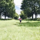 Хлопчик біжить полем — стокове фото