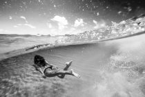 Mujer nadando bajo el agua en el mar - foto de stock