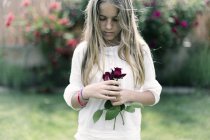 Hermosa chica sosteniendo rosas rojas - foto de stock