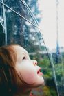 Girl leaning to window and watching rain drops — Stock Photo