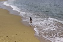 Chica corriendo en la playa - foto de stock