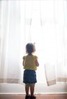Дівчина дивиться з вікна — стокове фото