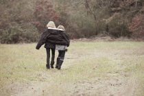 Sorelle che camminano insieme sul campo — Foto stock
