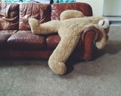 Фарширований плюшевий ведмідь лежить на дивані — стокове фото