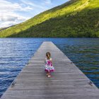 Bambina in piedi sul molo — Foto stock