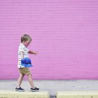 Niño caminando en la acera elevada - foto de stock