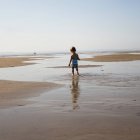 Ragazza a piedi sulla spiaggia — Foto stock