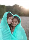 Две девушки, завернутые в одеяло — стоковое фото