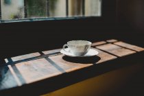 Xícara de café ao lado da janela — Fotografia de Stock