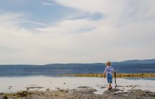Хлопчик ходить уздовж озера — стокове фото