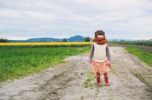 Petite fille debout dans le champ — Photo de stock