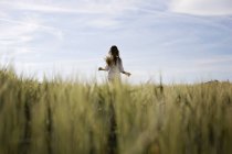 Девушка бежит по зеленому полю — стоковое фото