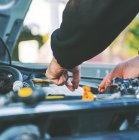 Чоловік ремонтує двигун автомобіля — стокове фото