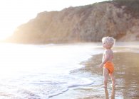Criança em pé na praia — Fotografia de Stock