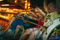 Family on amusement park ride — Stock Photo