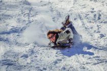 Mature woman having fun on sled — Stock Photo