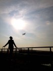 Чоловік дивиться на літак у небі — стокове фото