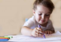 Junge zeichnet mit Buntstiften — Stockfoto