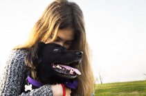 Teenage girl hugging dog — Stock Photo