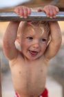 Niño sosteniendo barandilla metálica - foto de stock