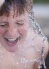 Éclaboussures d'eau sur le visage du garçon — Photo de stock