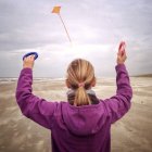 Дівчина літає повітряний змій на пляжі — стокове фото