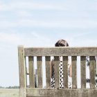 Fille assise sur le banc — Photo de stock