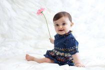 Baby girl playing with flower — Stock Photo