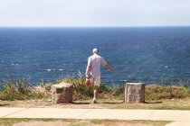 Людина, маючи фітнес перед Тихого океану — стокове фото