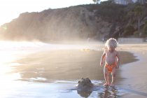 Bambino in piedi sulla spiaggia — Foto stock