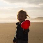 Petite fille tenant ballon rouge — Photo de stock