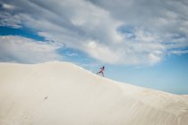 Menina correndo pela duna de areia — Fotografia de Stock